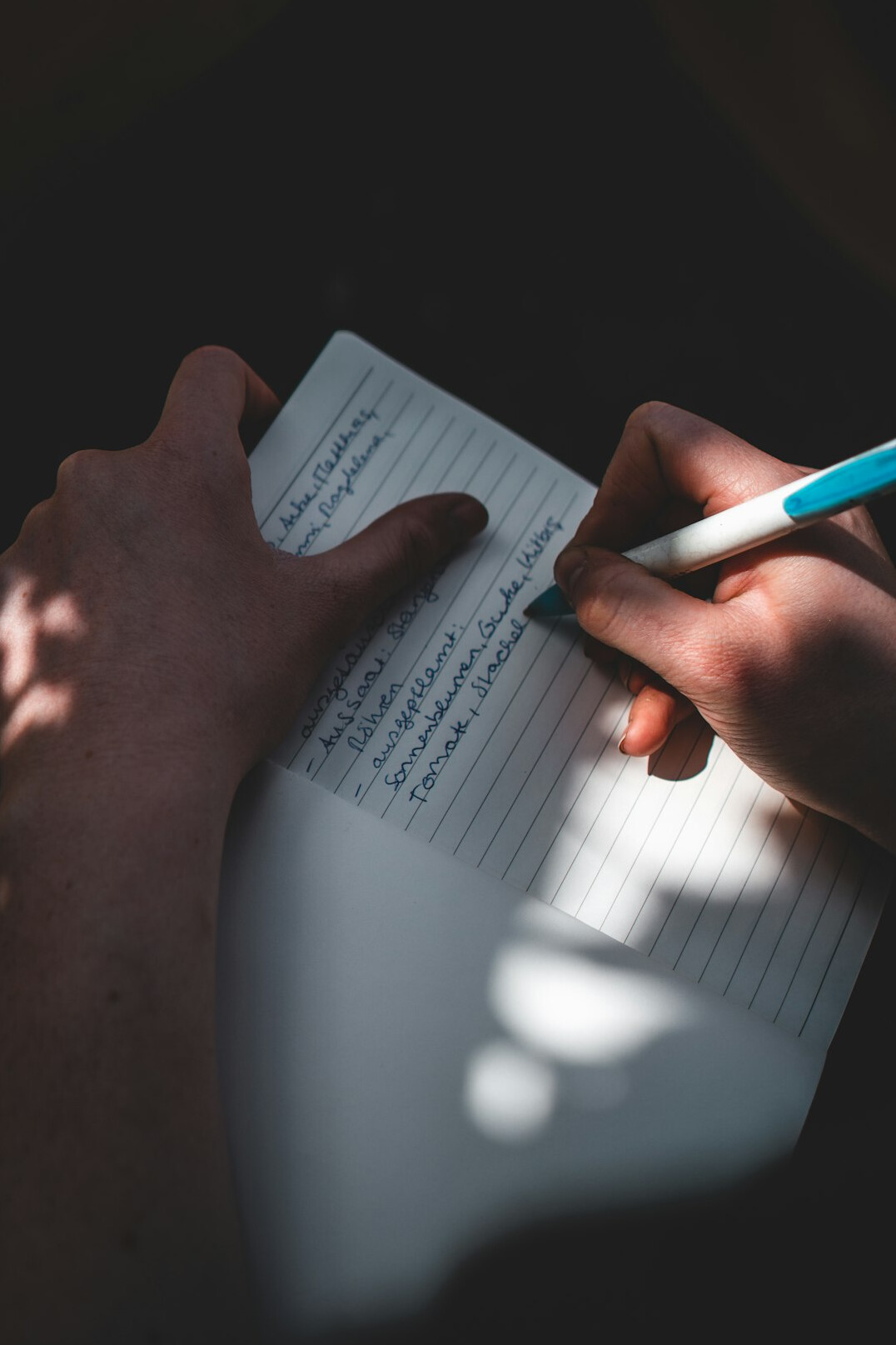 person writing goals in notebook