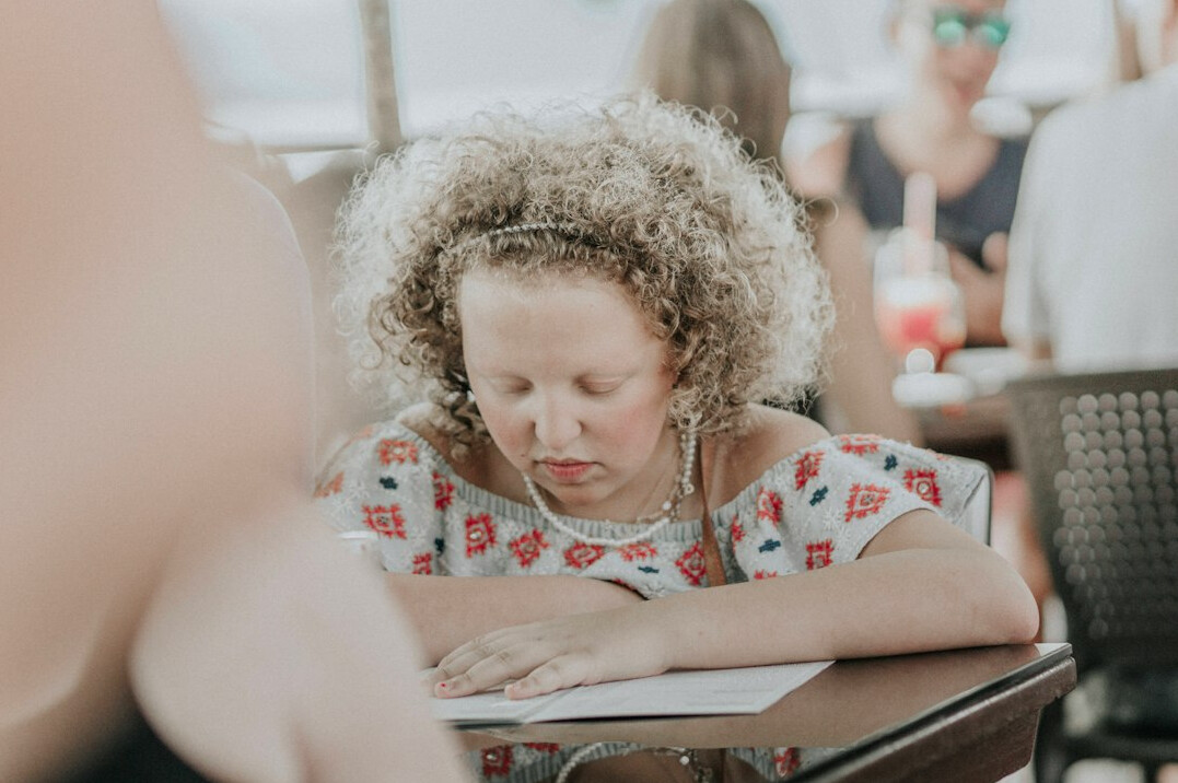 Brazilian woman writing notes while listening during a mentoring conversation